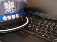 fot. poglądowa: czapka policyjna leżąca na laptopie