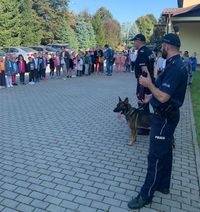 przewodnik i policyjny pies w czasie spotkania z uczniami szkoły podstawowej